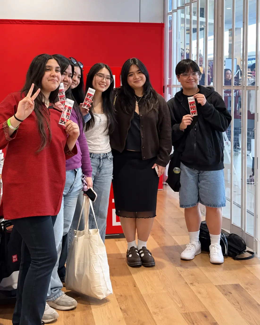 Guests holding their finished UNIQLO photostrips at the activation