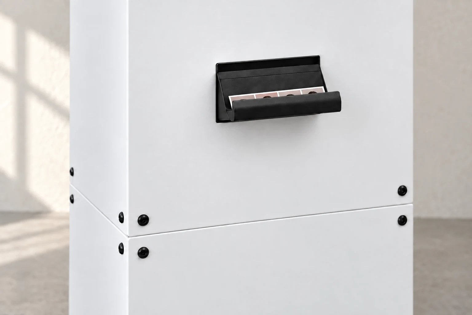 Photostrips resting in the booth’s black print catch, ready to collect